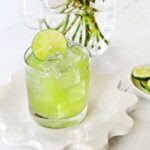 Vibrant green Incredible Hulk cocktail in a rocks glass with a lime garnish