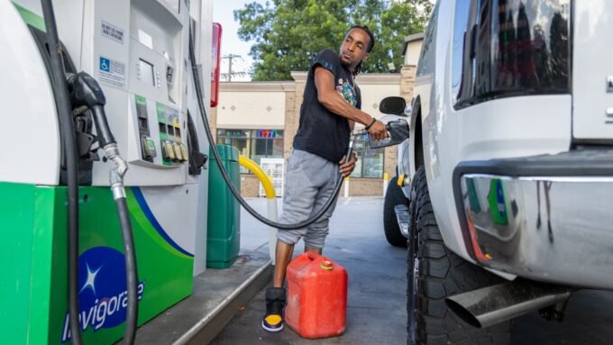 A person pumps gas at a Chevron gas station in Austin, Texas, highlighting rising fuel costs.