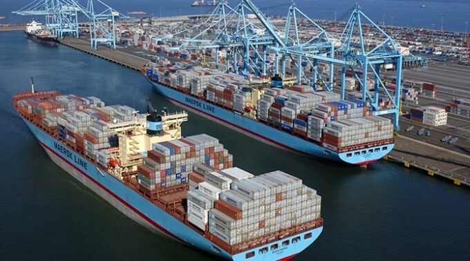 Vue aérienne d'un port marocain moderne avec des conteneurs et des navires, symbolisant la modernisation et la compétitivité du secteur portuaire.