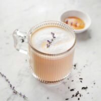 A steaming mug of homemade London Fog tea latte, topped with frothy milk and a sprinkle of dried lavender.