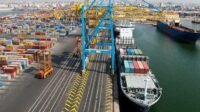 Vue aérienne d'un port marocain avec des conteneurs et des navires, symbolisant la croissance de l'activité portuaire.