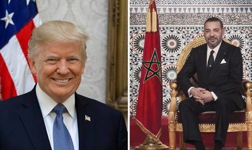 Vue aérienne de la voie express Tiznit-Dakhla, la « Donald J. Trump Highway », serpentant à travers les paysages du Sahara marocain, avec un panneau indiquant son nom.
