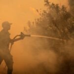 Mégafeu dévastateur dans le Var : Des milliers d'évacuations face à l'urgence climatique 6 Vue aérienne d'un feu de forêt intense dévorant une vaste étendue de végétation dans le Var, avec des panaches de fumée s'élevant dans le ciel.