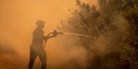 Vue aérienne d'un feu de forêt intense dévorant une vaste étendue de végétation dans le Var, avec des panaches de fumée s'élevant dans le ciel.