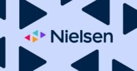 A person wearing a smartwatch, with a TV screen displaying streaming content in the background, symbolizing Nielsen's new measurement approach.