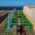 OCP Green Water : Le Maroc Dessine son Avenir Hydrique avec Deux Géants du Dessalement 8 Illustration d'une usine de dessalement d'eau de mer avec des infrastructures de transport d'eau, symbolisant l'innovation et la durabilité.