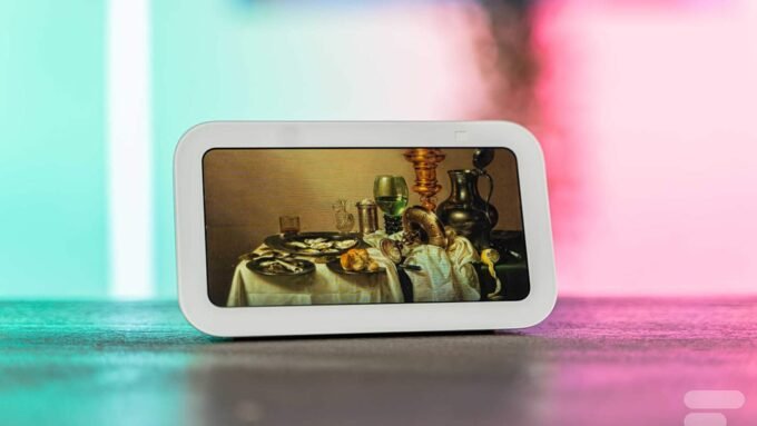 L'Amazon Echo Show 5 (2023) de face, affichant une interface colorée, posé sur une surface claire.