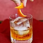 Mastering the Old Fashioned: Your Ultimate Guide to a Timeless Cocktail 6 A perfectly crafted Old Fashioned cocktail in a rocks glass with a large ice cube and an orange peel garnish.