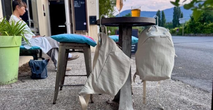 Peak Design's City Line Bags: The Ingenious Hook That Changes Everything 9 A Peak Design City Line crossbody bag with its innovative BagLev hook deployed, hanging from a cafe table, keeping the bag off the ground.