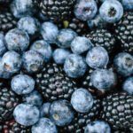 A vibrant assortment of polyphenol-rich foods like berries, coffee, and cocoa, symbolizing gut health and exercise recovery.