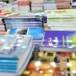Libraire au Maroc avec des étagères de manuels scolaires, symbolisant la pénurie et la hausse des prix à la rentrée.