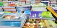 Libraire au Maroc avec des étagères de manuels scolaires, symbolisant la pénurie et la hausse des prix à la rentrée.