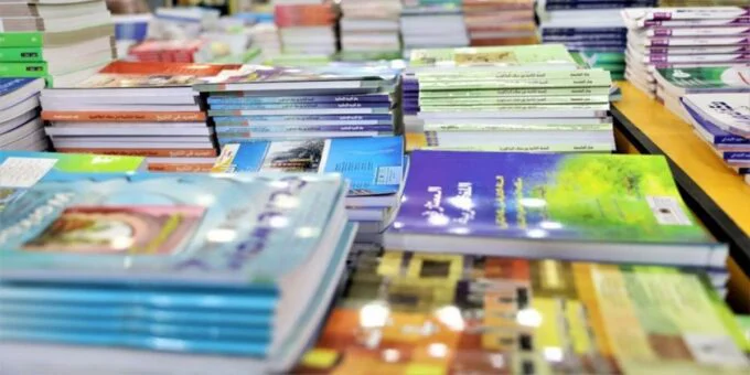 Libraire au Maroc avec des étagères de manuels scolaires, symbolisant la pénurie et la hausse des prix à la rentrée.