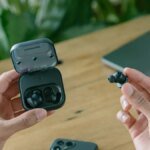 A collection of wireless earbuds, some with their battery compartments open, symbolizing repairability.