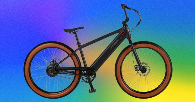 Electric blue Retrospec Joe Rev 2 e-BMX bike being ridden on a street