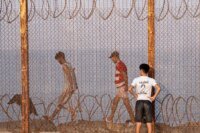 Des migrants, incluant femmes, hommes et enfants, tentent de franchir la frontière de Sebta, illustrant les défis de la mobilité humaine entre l'Afrique et l'Europe.