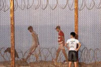 Des migrants, incluant femmes, hommes et enfants, tentent de franchir la frontière de Sebta, illustrant les défis de la mobilité humaine entre l'Afrique et l'Europe.