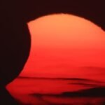 The solar corona glowing around the moon during the total solar eclipse over Arenal Beach in Llucmajor, Mallorca.