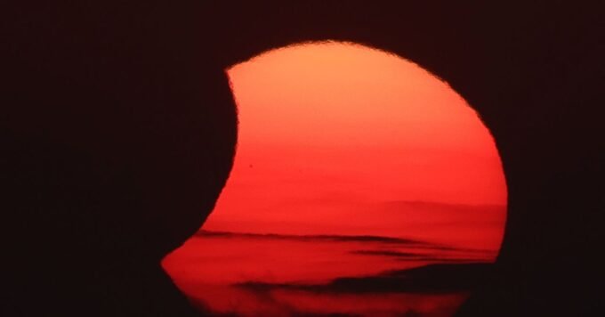 The solar corona glowing around the moon during the total solar eclipse over Arenal Beach in Llucmajor, Mallorca.