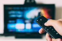 Une image d'illustration montrant un écran de télévision avec des icônes de streaming, symbolisant le streaming illégal et les défis technologiques.