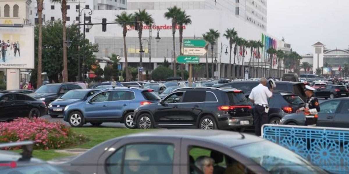 Vue aérienne d'un embouteillage dense sur une artère principale de Tanger en pleine saison estivale, avec des véhicules à l'arrêt.