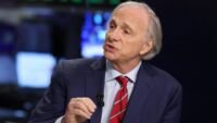 Ray Dalio speaking at the New York Stock Exchange, discussing economic forecasts and investment strategies.