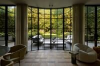 Exterior view of a modern Vancouver home addition featuring floor-to-ceiling glass, seamlessly integrating with the surrounding garden, photographed by Ema Peter.
