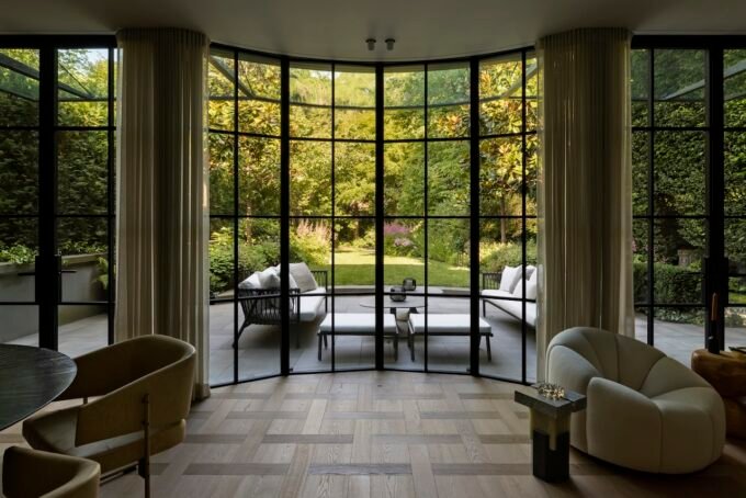 Exterior view of a modern Vancouver home addition featuring floor-to-ceiling glass, seamlessly integrating with the surrounding garden, photographed by Ema Peter.
