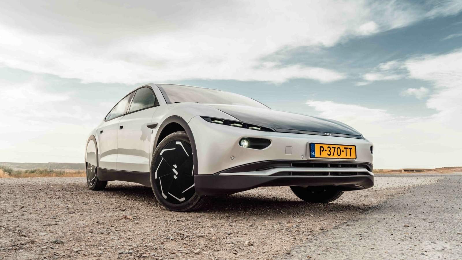 Une voiture électrique moderne garée devant une maison équipée de panneaux solaires sur le toit, symbolisant la recharge solaire domestique et l'intégration des énergies renouvelables dans la mobilité.