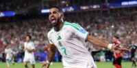 Riyad Mahrez en maillot de football, potentiellement retouché aux couleurs du Wydad de Casablanca, ou une image générique de lui en action.