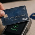 Illustration of a credit card being scanned by a payment terminal with a 'zombie' hand reaching out, symbolizing the Zombie Card attack.
