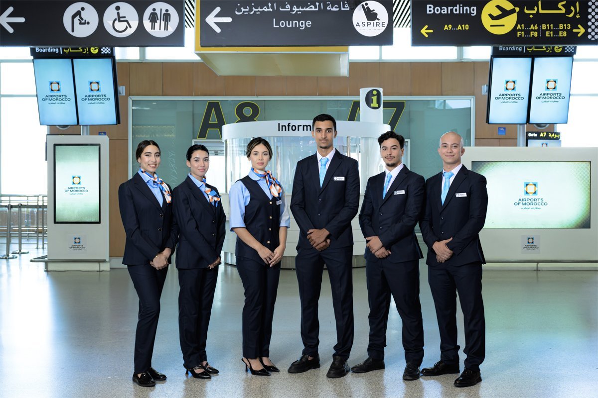 Les équipes d'accueil de l'ONDA dans leurs nouvelles tenues aux couleurs d'Airports of Morocco, souriantes et prêtes à assister les voyageurs dans un aéroport moderne.