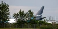 Emergency services at the scene of an Amazon Prime Air cargo plane crash at Miami International Airport, with debris scattered and smoke visible.