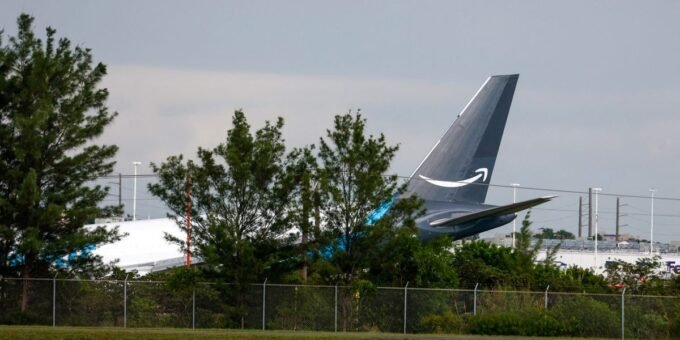 Tragedy in Miami: Amazon Prime Air Cargo Plane Crash Claims Multiple Lives 10 Emergency services at the scene of an Amazon Prime Air cargo plane crash at Miami International Airport, with debris scattered and smoke visible.