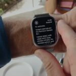 Close-up of an Apple Watch displaying a text summary, symbolizing the new Audio Intelligence features.