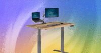 A modern standing desk with a computer setup, transitioning between sitting and standing positions.