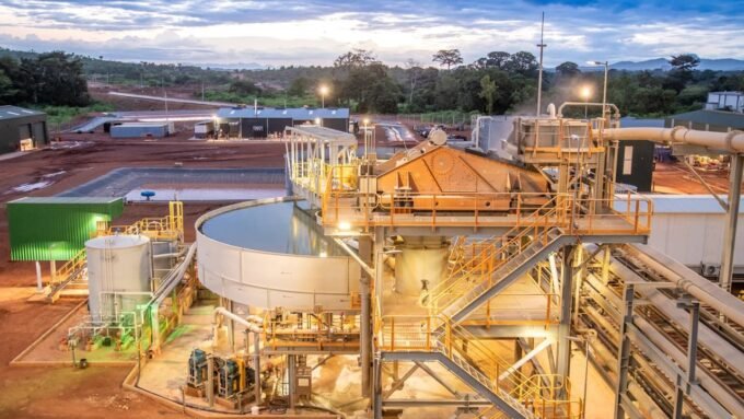 L'Or Ivoirien : Abidjan à la Conquête d'un Avenir Minier Réglementé et Prospère 9 Vue aérienne d'une mine d'or ivoirienne en exploitation, avec des équipements lourds et des structures industrielles, sous un ciel clair.