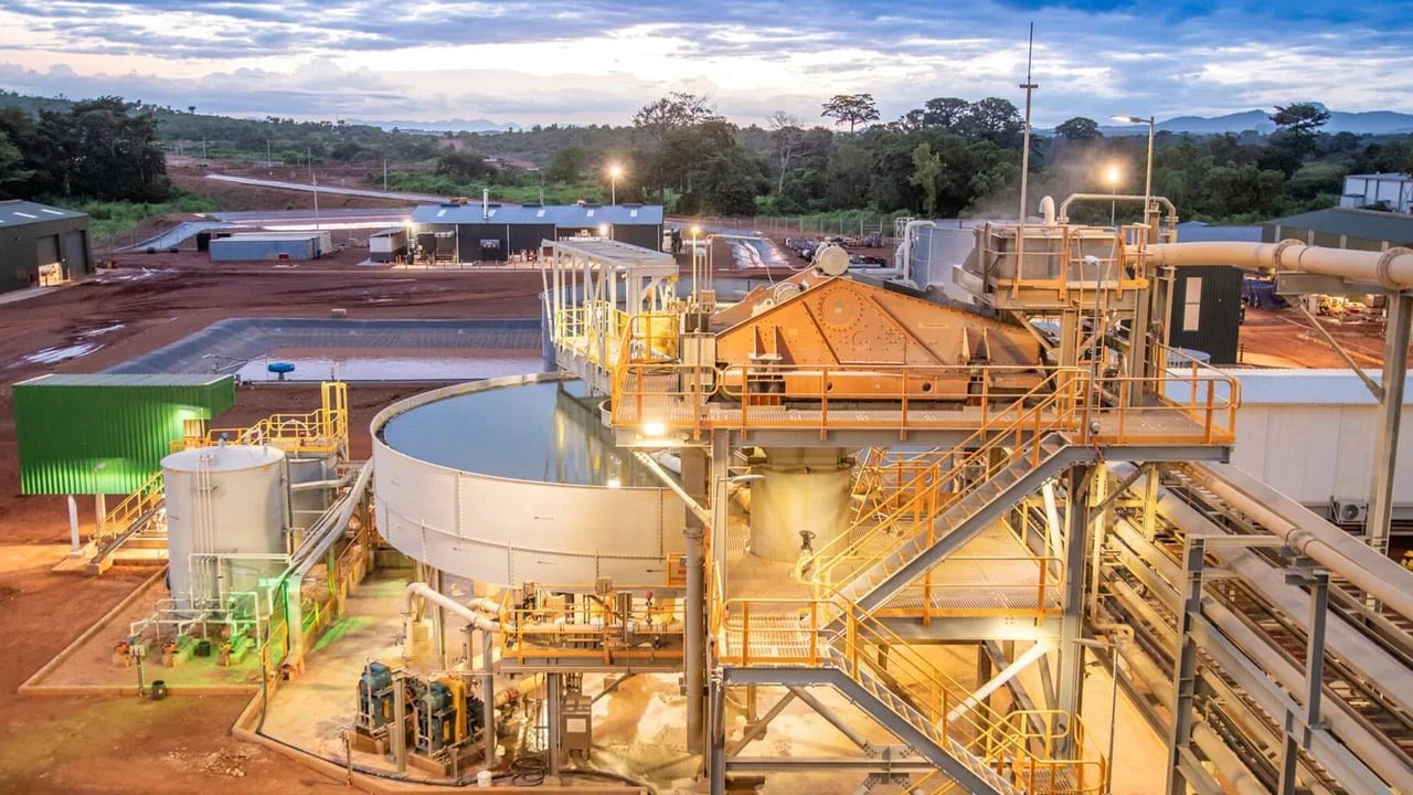 L'Or Ivoirien : Abidjan à la Conquête d'un Avenir Minier Réglementé et Prospère 3 Vue aérienne d'une mine d'or ivoirienne en exploitation, avec des équipements lourds et des structures industrielles, sous un ciel clair.