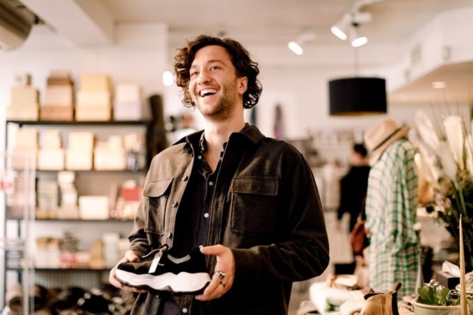 A customer walking into a well-lit, inviting business space, with a friendly staff member in the background.