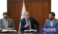 شعار نادي الوداد الرياضي مع إشارة إلى الأزمة المالية والمنع الدولي.