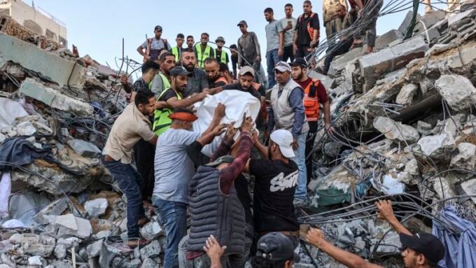فرق إنقاذ تبحث عن ناجين تحت أنقاض مبنى سكني منهار في حي الرمال بمدينة غزة.