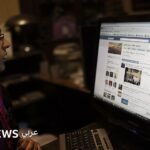 فتاة مصرية تتصفح هاتفها الذكي على موقع فيسبوك