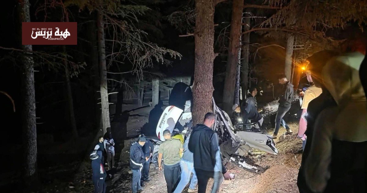 صورة لموقع حادث سير مروع بمدخل جماعة إساكن بإقليم الحسيمة، يظهر بقايا سيارة متضررة وعناصر الإنقاذ.