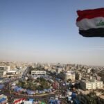 صورة تظهر عملات الدولار الأمريكي مع خريطة العراق في الخلفية، ترمز إلى العلاقات المالية بين البلدين وشحنات الدولار.