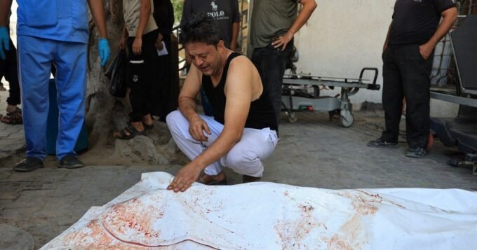 أب فلسطيني يبكي بجانب جثمان ابنه محمد عبد الزناتي في مستشفى الشفاء بغزة بعد ضربة جوية إسرائيلية.