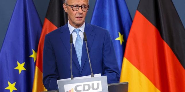 Friedrich Merz, leader de la CDU, le visage grave, devant un fond flou symbolisant l'incertitude politique, après une défaite électorale en Allemagne.