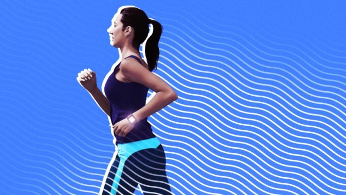 A person looking at their fitness tracker displaying calorie burn data on their wrist