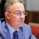 Fouzi Lekjaa s'exprimant devant un auditoire de la CGEM, avec le logo du PAM en arrière-plan, symbolisant l'engagement du parti sur la fiscalité des entreprises et la lutte contre l'informel.