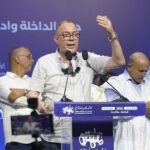 Fouzi Lekjaa, membre du bureau politique du PAM, s'exprimant lors d'une rencontre à Dakhla, avec le logo du parti en arrière-plan.