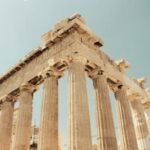 Panoramic view of the majestic Acropolis in Athens at sunset, with the city lights twinkling below.